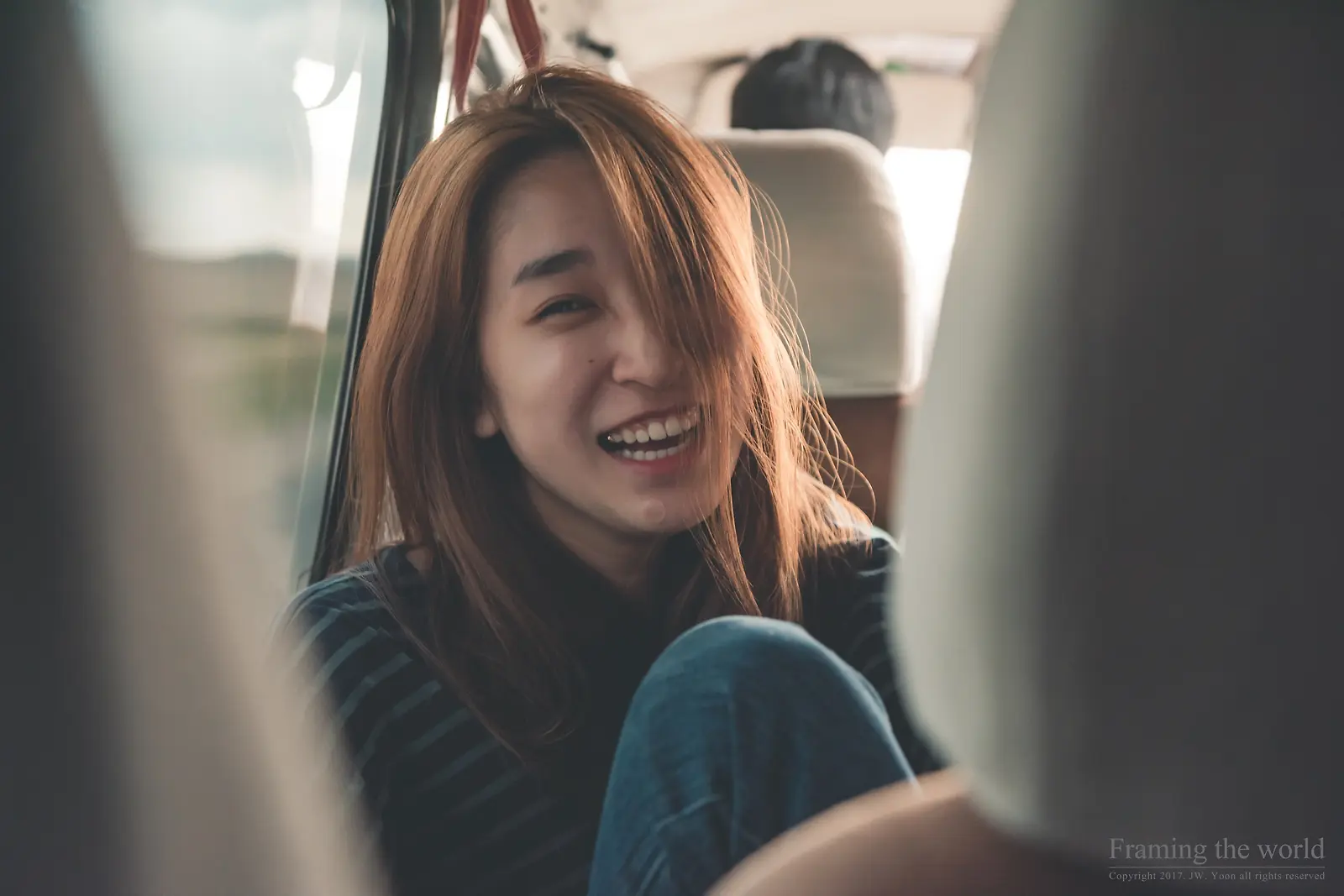 여행 차량 좌석에 앉아 환하게 웃는 동행