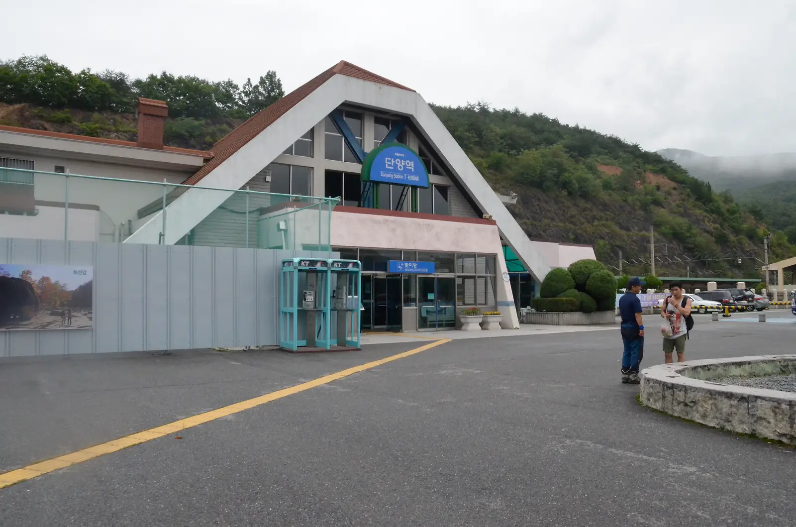 산을 뒤로하고 서 있는 해운대역 건물과 입구 앞의 여행객들
